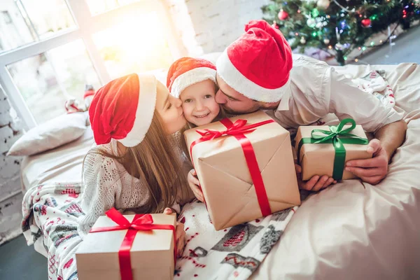 Boże Narodzenie Rodziny Szczęścia Rodzice Całując Jej Córeczkę Santa Kapelusze — Zdjęcie stockowe