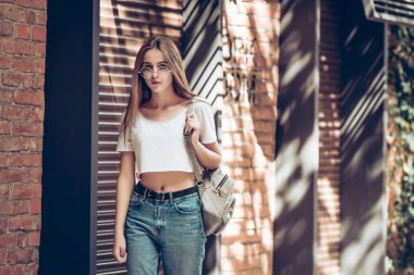 Şehirde mutlu bir kadın portresi. Açık havada şehir caddede yürüyüş ve kameraya poz moda kadın.
