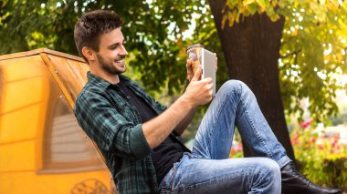 Boş zaman etkinliği. Genç bir adam bir parkta bir fotoğraf yapmak atış.