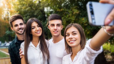 Peynir deyin. Kampüste dersten önce bir cep telefonunda bir selfie alan öğrenciler kadeh.