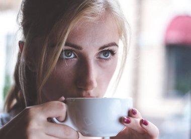 Onun gün bir bardak taze kahve ile başladı. Sabah kahvesini yudumlarken düşünceli arayan genç bir kadın.