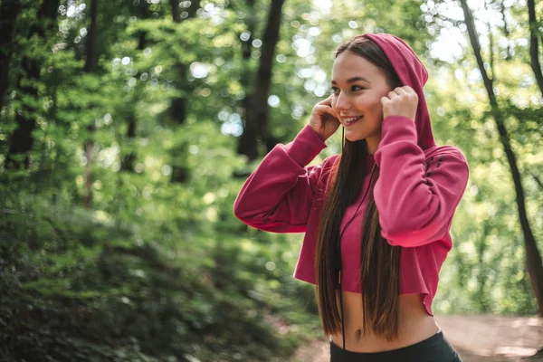 Jonge Atleet Vrouw Roze Hoodie Zetten Van Hoofdtelefoon Het Forest — Stockfoto