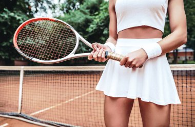 Raket elinde tutan tenisçi. Closeup görünümünü tenis raketi sahada tutan genç bir kadın. Tenis Kulübü sağlıklı yaşam tarzı.