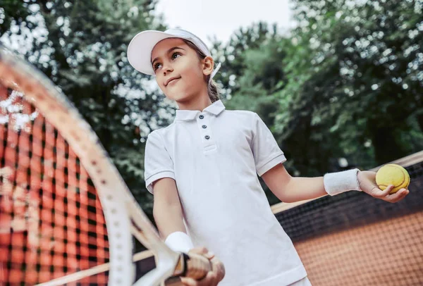 テニスコートで子供のためのアクティブな運動 テニスコートのスポーティな女の子の肖像画 子供のための夏の活動 子供女の子テニス ボール屋外を提供する準備ができて — ストック写真