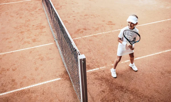 Child playing tennis on outdoor court. Little girl with tennis racket and ball in sport club. Active exercise for kids. Summer activities for children. Training for young kid. Child learning to play. top view