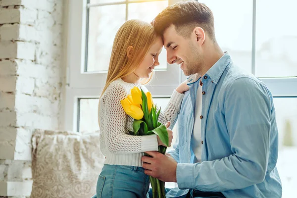 Linda niña y su padre guapo. Padre da flores de ramo a su hija pequeña . —  Fotos de Stock