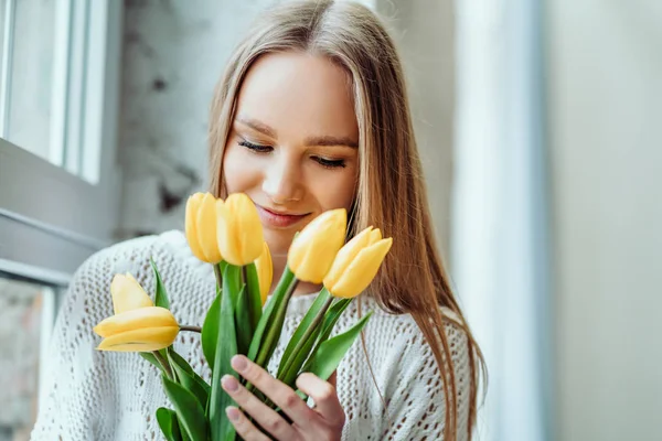 Ik hou van lente en de bloemen. Portret van mooie vrouw met boeket van gele tulpen. Schoonheid en tederheid concept. — Stockfoto