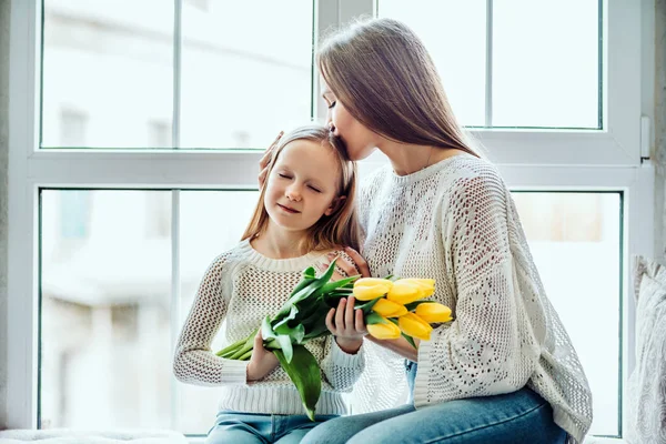 Onlar birbirlerini hazine. Sevgi dolu bir anne ve kızı evde pencere pervazına üzerinde oturan.