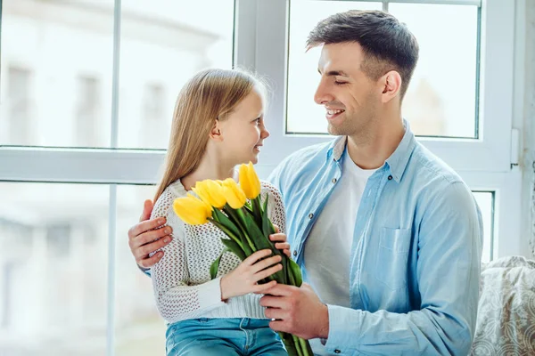Time with dad is always great.Father gives her daughter a bouquet of tulips. — Stock Photo, Image