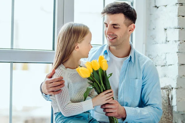 Spending some quality time with my dad..Father gives her daughter a bouquet of tulips. — Stock Photo, Image