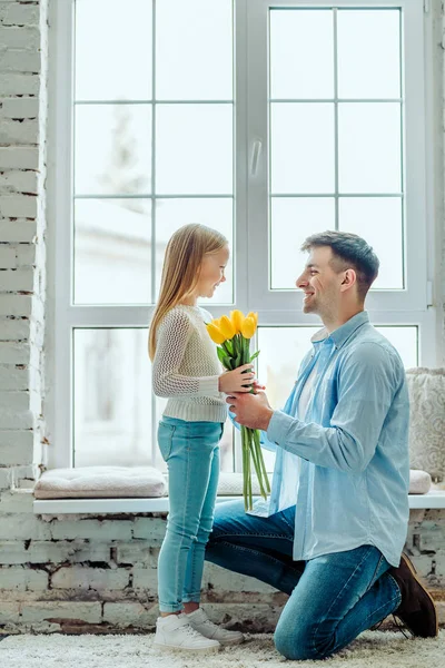 Estas flores são para ti. Papai dá a filha um buquê de tulipas . — Fotografia de Stock