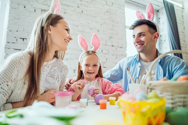 Keluarga time.Lovely keluarga melukis easter telur bersama-sama. Happy gadis kecil memegang telur Paskah di tangan . — Stok Foto