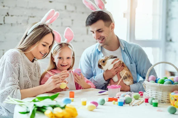 Güzel gelenekleri seviyoruz. Anne ve kızı yumurta, boya baba tutar ev dekoratif tavşan.