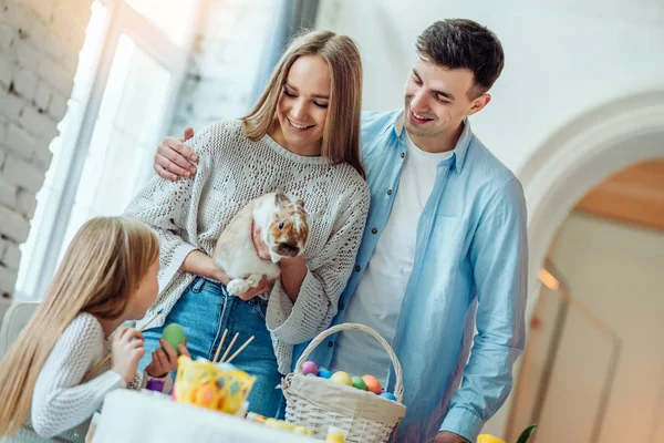 Criar uma atmosfera de Páscoa juntos.Família amorosa conta a sua filha sobre o coelho da Páscoa e tradições do feriado. Conceito de celebração . — Fotografia de Stock