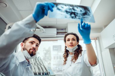 Sağlık, tıp ve radyoloji kavramı - iki diş hekimi doktor x-ray bakıyor. seçici odaklama.