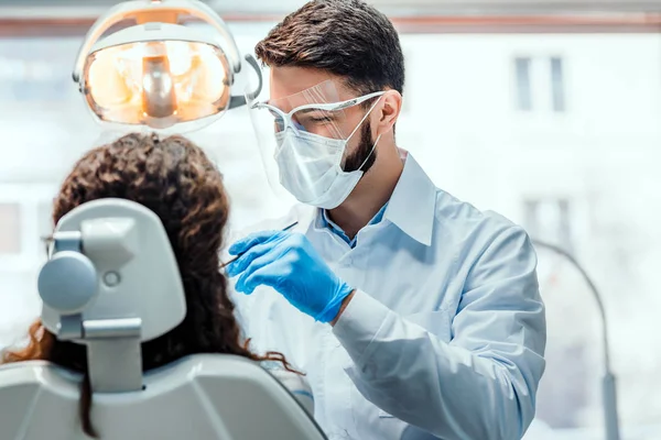 Dentist working in dental clinic with patient in the chair. — Stock Photo, Image