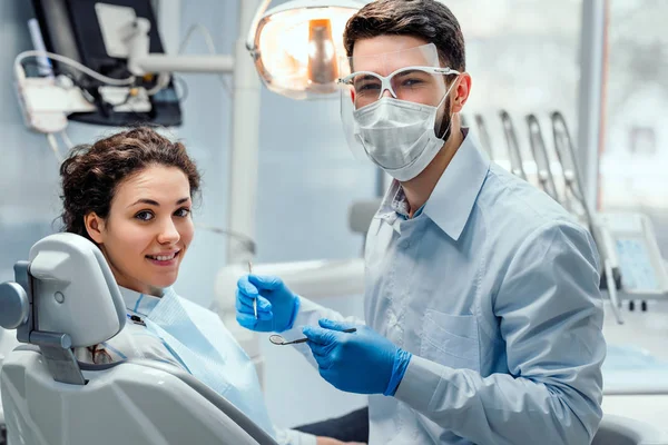 Bella paziente donna che ha un trattamento odontoiatrico nello studio del dentista. Donna dal suo dentista . — Foto Stock