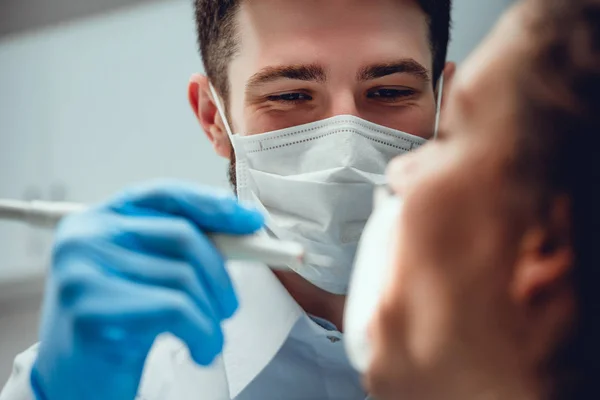 Un dur labeur. La concentration sélective des mains masculines portait des outils dentaires tandis que le dentiste masculin sérieux portant le masque. Vue rapprochée . — Photo