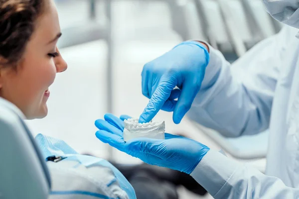 Dentista explicando los detalles del molde dental a su paciente. Vista de cerca . — Foto de Stock