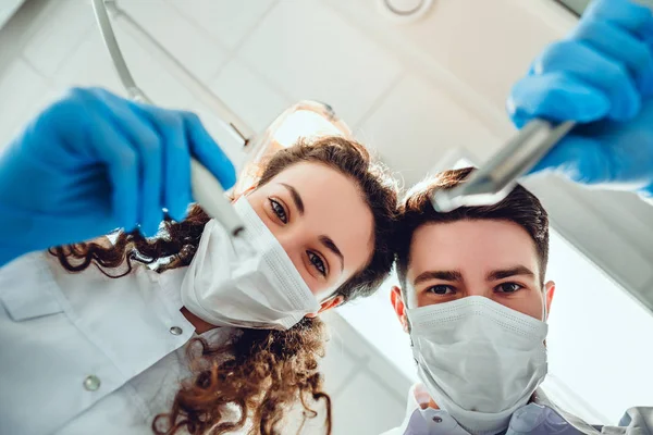 Två tandläkare undersöker tänder, patienter perspektiv. Närbild Visa. — Stockfoto