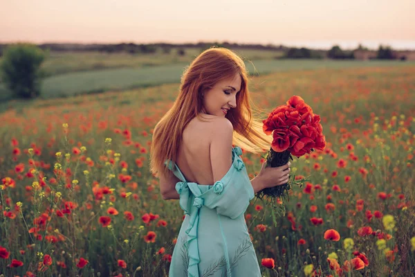 Mulher de pé no campo de papoila floração — Fotografia de Stock