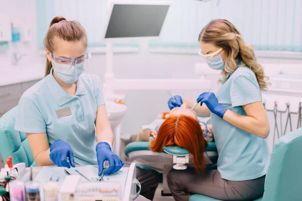 Młoda kobieta asystent przygotowuje narzędzia dla lekarza dentysty — Zdjęcie stockowe