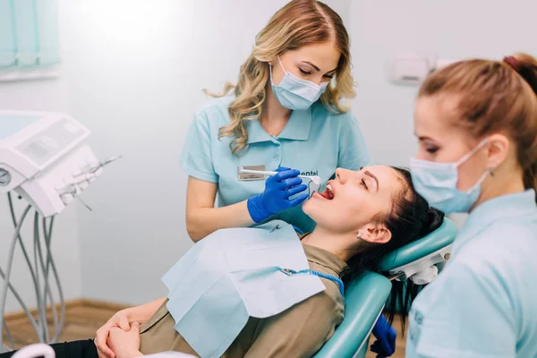 Młoda kobieta jest badany przez stomatologa — Zdjęcie stockowe