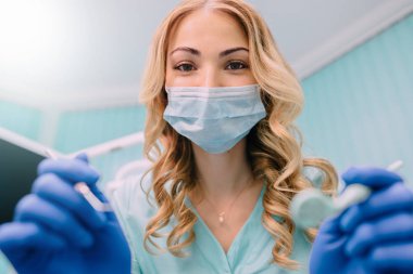 Genç kadın dişçi hasta ağız inceliyor