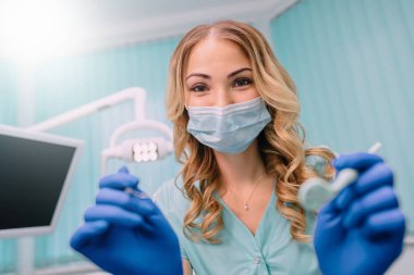 kadın dişçi hasta üzerinde incelemek için eğildi