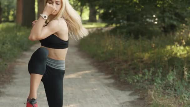 Jovem mulher aquecimento antes de correr no parque — Vídeo de Stock