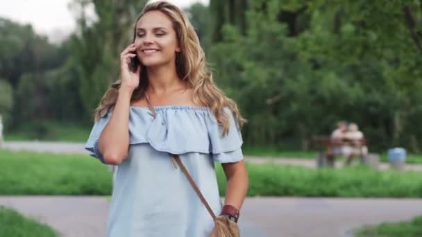 Wesoły kobieta rozmawia telefon spaceru w parku — Wideo stockowe