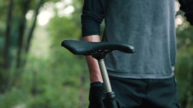 Adam bisiklet eyerini tamir ediyor, yakın plan.