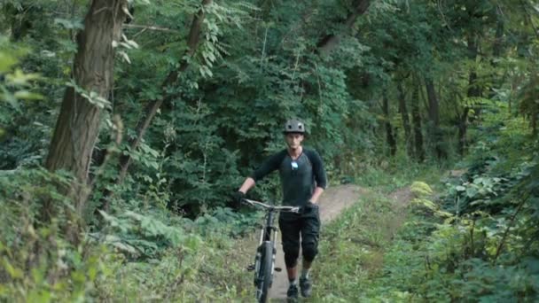 Extreme fietser komt met fiets in het bos — Stockvideo