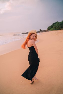 gün batımı, arka görünüm vasıl belgili tanımlık kıyı boyunca yürüyen genç kadın