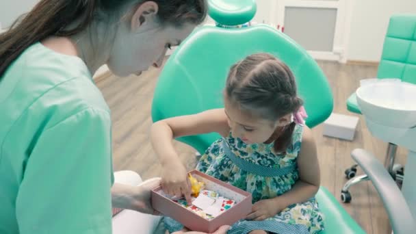 Dentista niños entretiene niña — Vídeo de stock