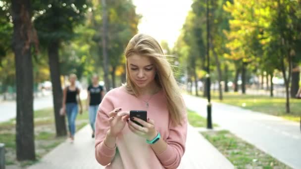 Menina está usando smartphone na rua — Vídeo de Stock