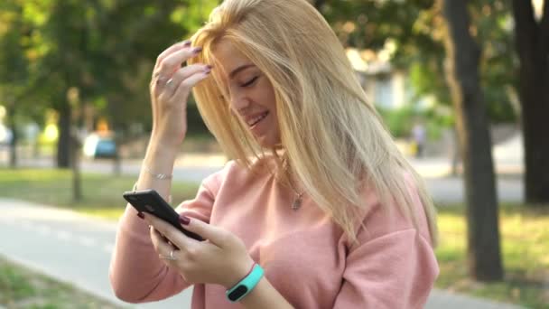 Girl is using smartphone on street — Stock Video