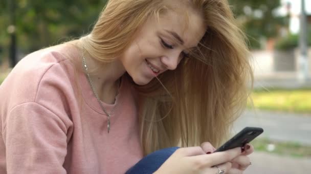 Young girl is typing message on phone — Stock Video