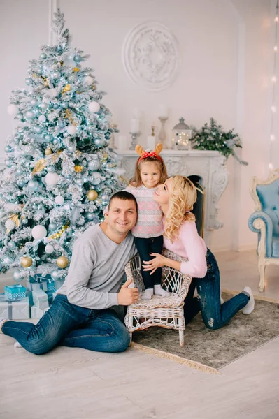 Padres jóvenes jugando con el bebé cerca del árbol de Navidad —  Fotos de Stock