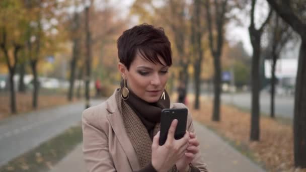 Porträtt av ung kvinna med telefon på gatan — Stockvideo