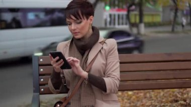Genç erkek smartphone bankta otururken kullanır