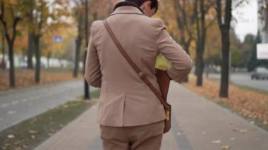 Genç kadın sokakta yürürken telefonda söz