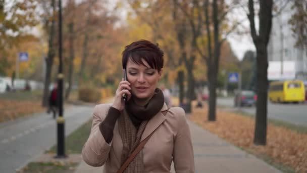 Genç kadın mutlu bir şekilde telefon Caddesi üzerinde söz — Stok video