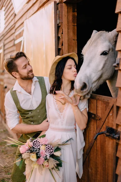 Eleganta nygifta kramas nära häst, lantliga stil — Stockfoto