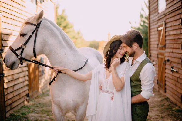 Recém-casados elegantes abraçando perto de cavalo, estilo country — Fotografia de Stock