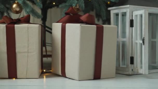 Christmas gifts in boxes under tree, close up — Stock Video