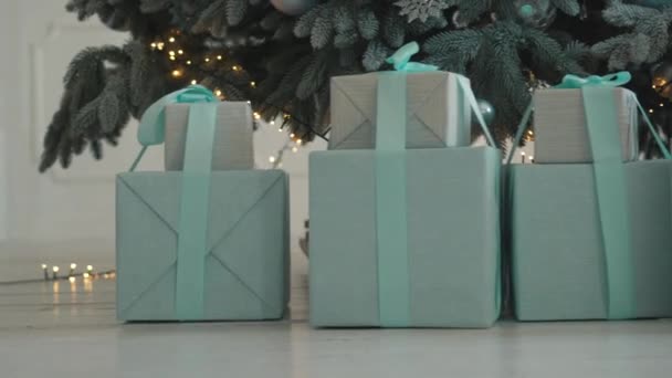 Christmas gifts in boxes under tree, close up — Stock Video