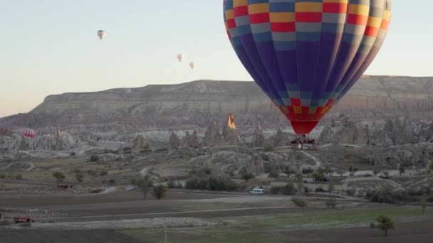 Groep mensen vliegen in de ballon over rotsen — Stockvideo