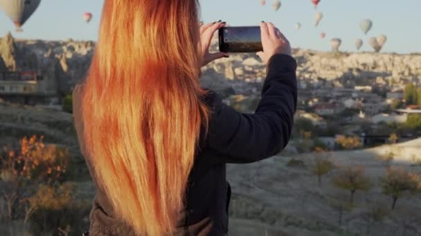 Молодая женщина снимает видео воздушных шаров в Каппадокии — стоковое видео