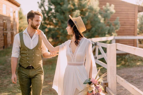 Les jeunes mariés de style boho marchent sur le ranch, jour d'été — Photo